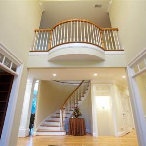 View of half round stair case and balcony from foyer